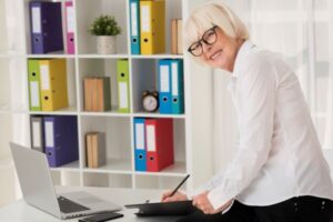 smiley-senior-sentado-em-seu-escritorio
